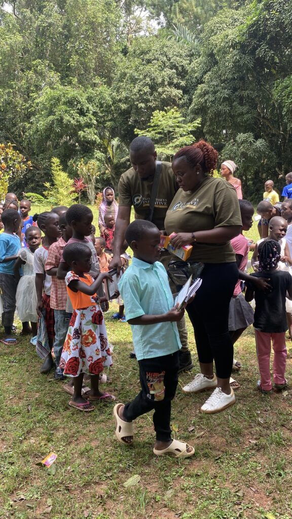 Students in rural Ugandan tourism community receiving new school supplies