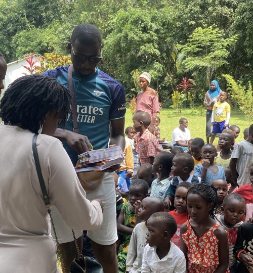 Ugandan pupils receiving scholastic materials in tourism community from Tatu a charitable travel community in the pearl of Africa