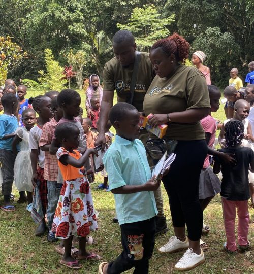 Students in rural Ugandan tourism community receiving new school supplies